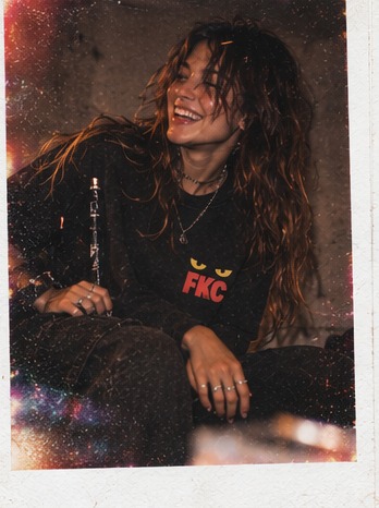 Instant photo of a smiling model in a black Feral Kitty Club tee