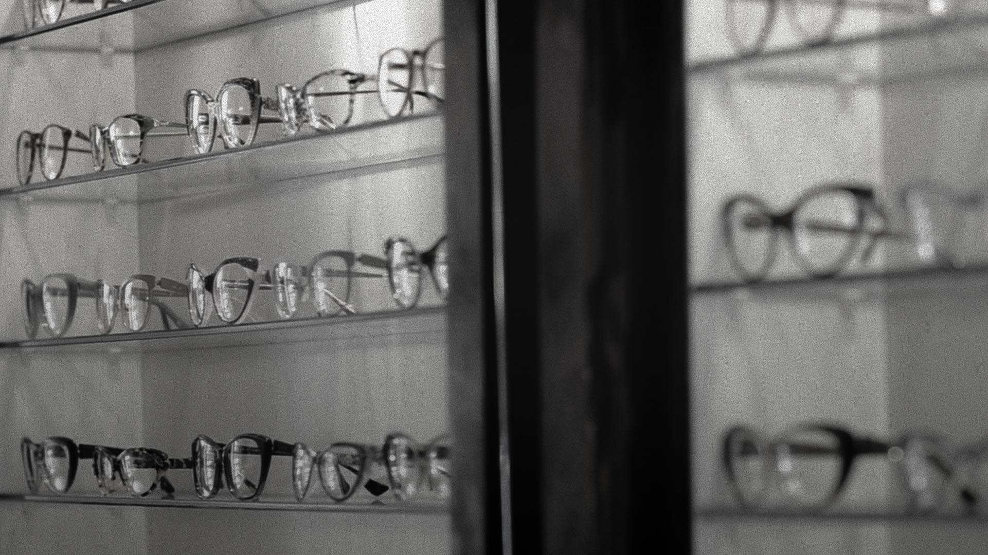Black-and-white photo of eyeglass frames on display shelves